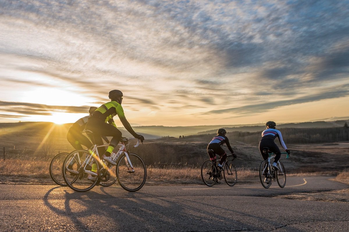 4 bikers on the Cochrane Horse Creek bike trail at sunset