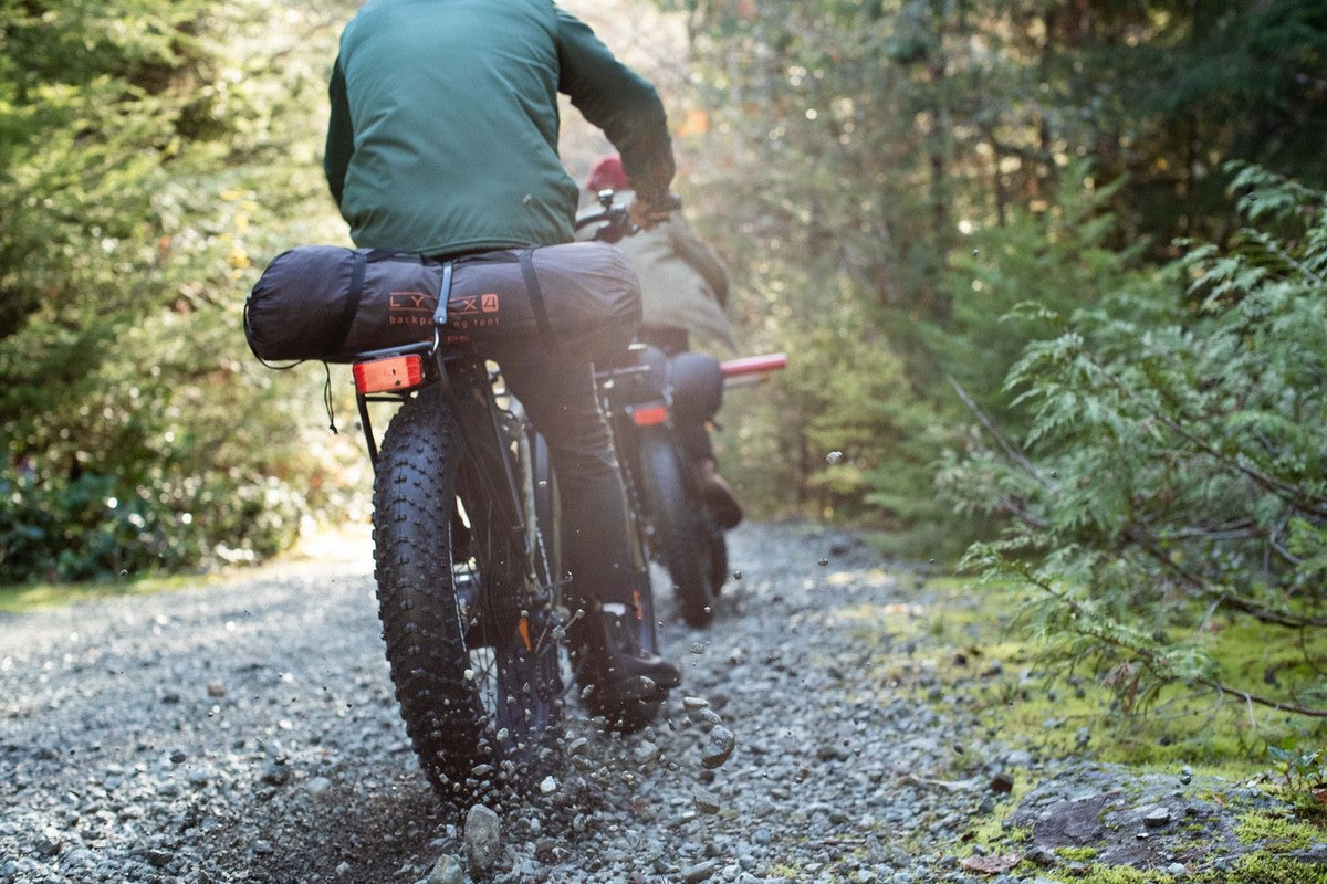 Two riders on Boar Explorer eBikes in forest