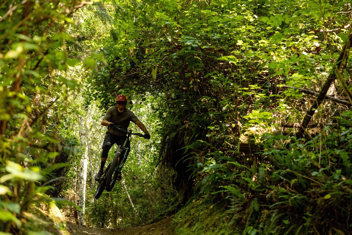 Man on electric mountain bike riding through forest