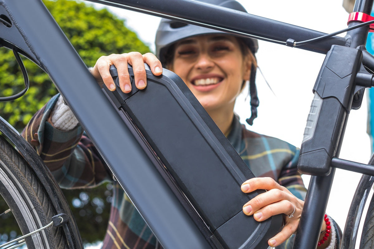 eBike rider checking battery and other parts in her eBike before trip through city